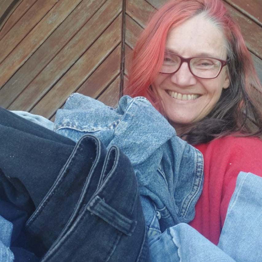 Lady holding up denim clothing for upcycling