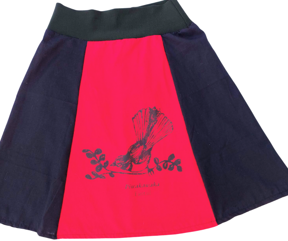 Artisanal detail of the Heke Design screenprinting process on upcycled red fabric, showcasing the 'one of one' nature of our Waiheke-made garments.
