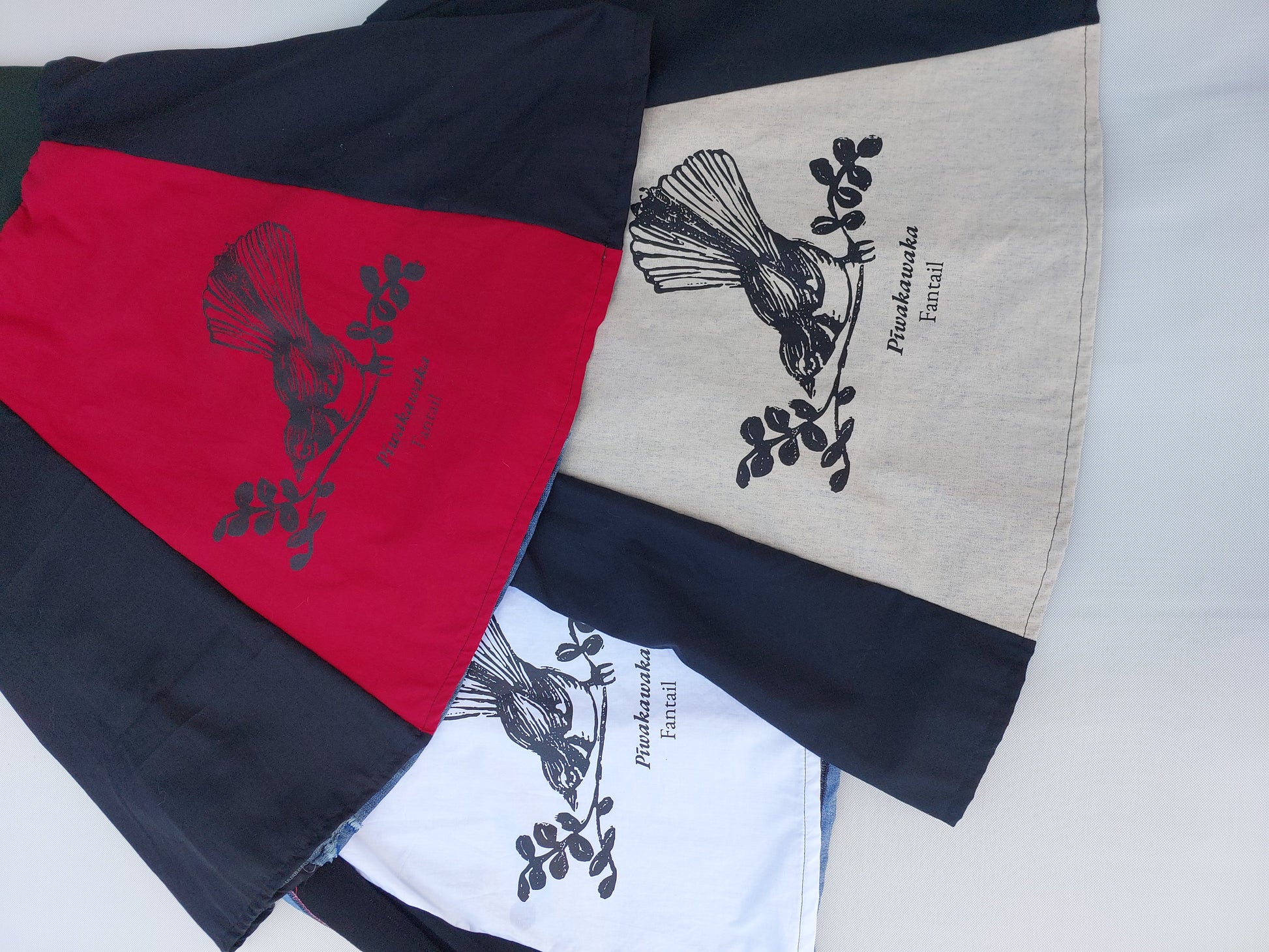 Upcycled denim A-line skirt featuring a hand-screenprinted NZ fantail motif on the front panel.