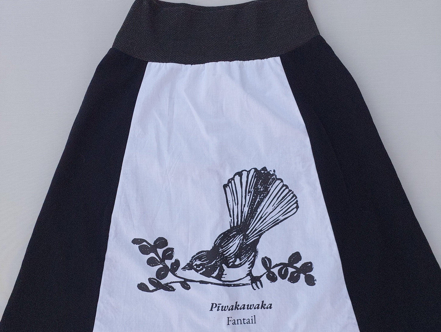 Artisanal detail of the Heke Design screenprinting process on upcycled white fabric, showcasing the 'one of one' nature of our Waiheke-made garments.