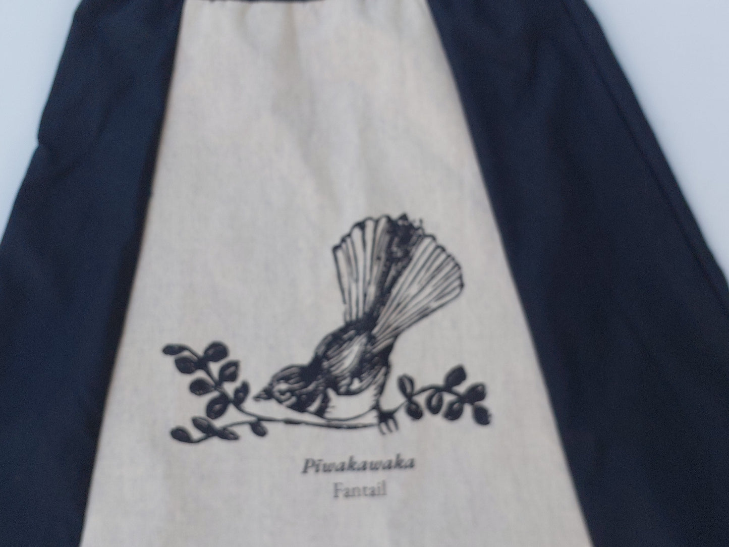 Artisanal detail of the Heke Design screenprinting process on upcycled navy fabric, showcasing the 'one of one' nature of our Waiheke-made garments.