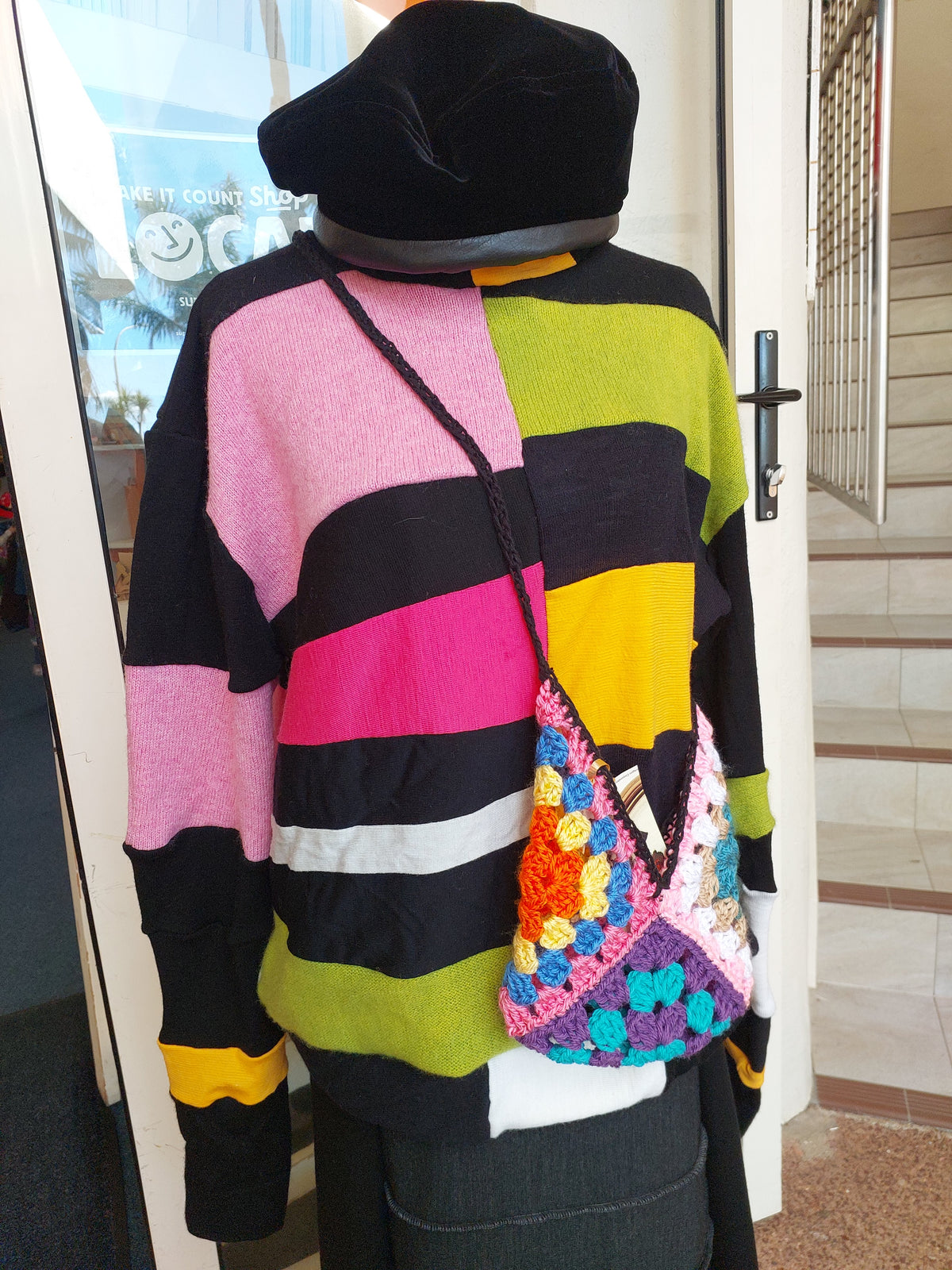 Unisex upcycled merino wool turtleneck sweater with vibrant patchwork blocks in black, yellow, pink, and green.